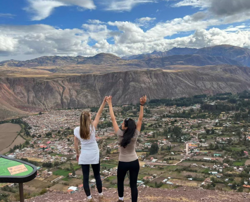 Zwei junge Frauen auf dem Berg mit Händen in die Höhe