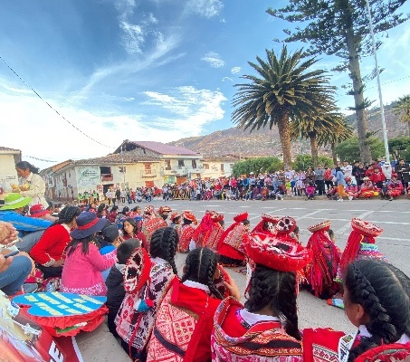 Personen sitzen auf der Straße in peruanischer Tracht