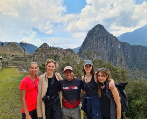 Personen stehen vor Bergen in Peru und blicken in die Kamera